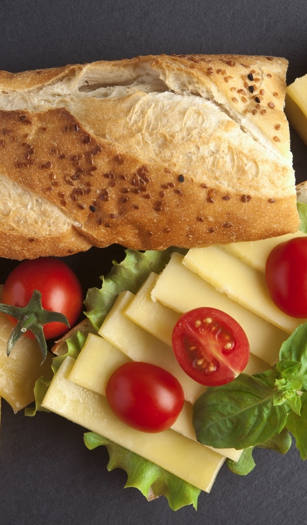 Сыр с батоном и помидорами на столе