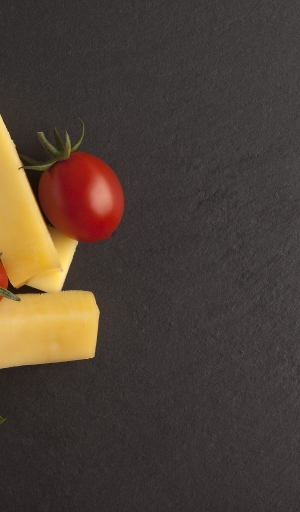 Сыр с помидорами и листьями базилика на сером столе