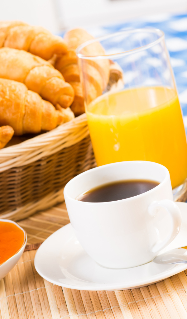 Кофе с круассанами и соком на столе на завтрак