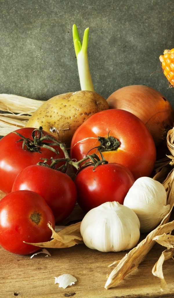 Кукуруза, чеснок и помидоры на столе