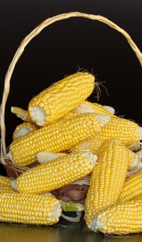 Кукуруза в корзине на черном фоне