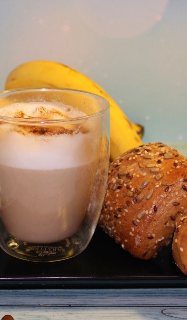 Чашка какао на столе с булочками и бананами