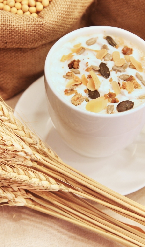 Чашка молока с хлопьями на столе с пшеницей