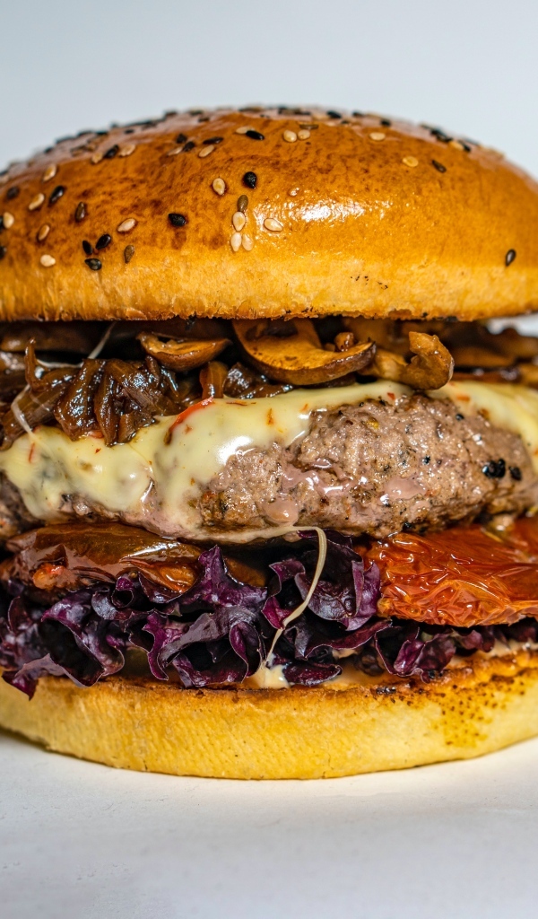 Ароматный сочный гамбургер на сером фоне крупным планом