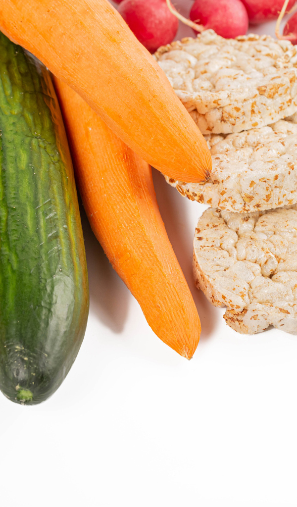 Свежие аппетитные овощи и хлопья на белом фоне