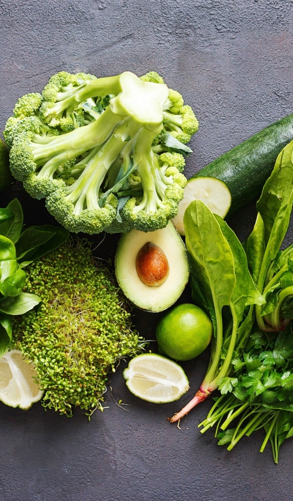 Свежие зеленые овощи на сером столе