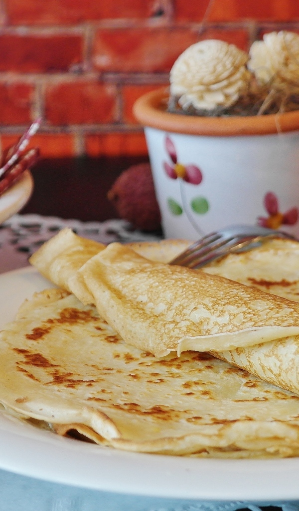 Свежие блины на столе с яйцами