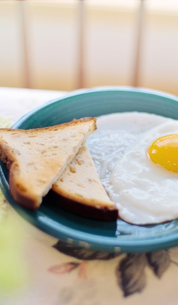 Яичница с хлебом на столе на завтрак 
