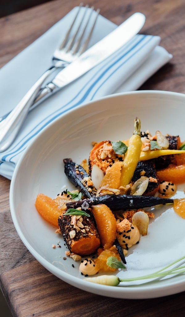 Жареные овощи на тарелке со столовыми приборами