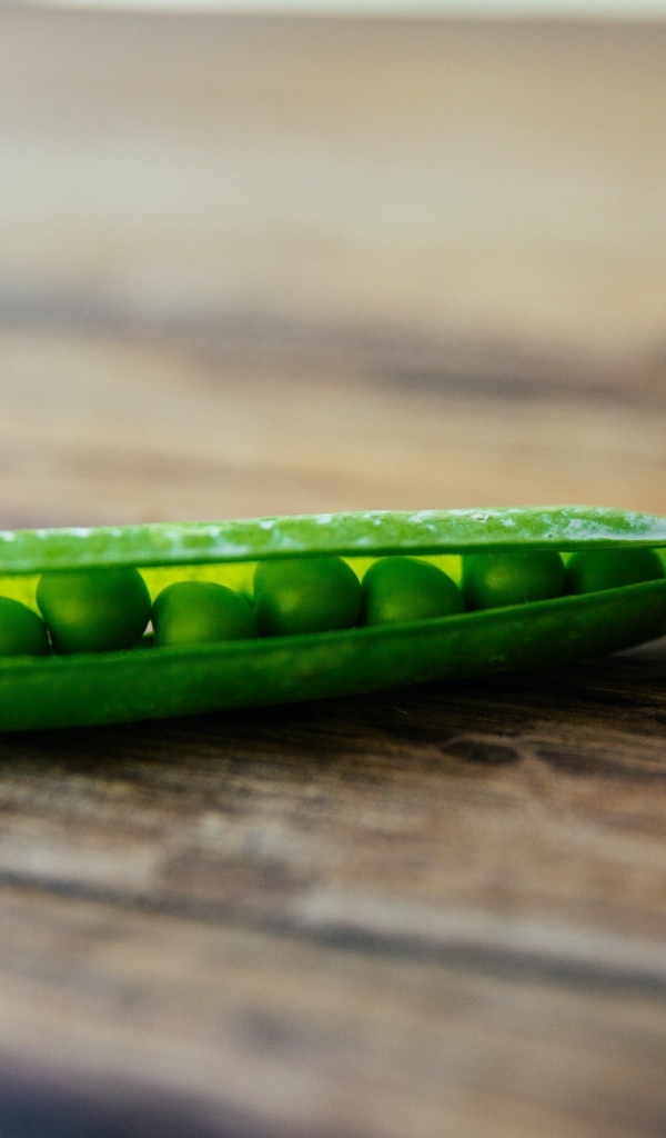 Зеленый горох на деревянном столе