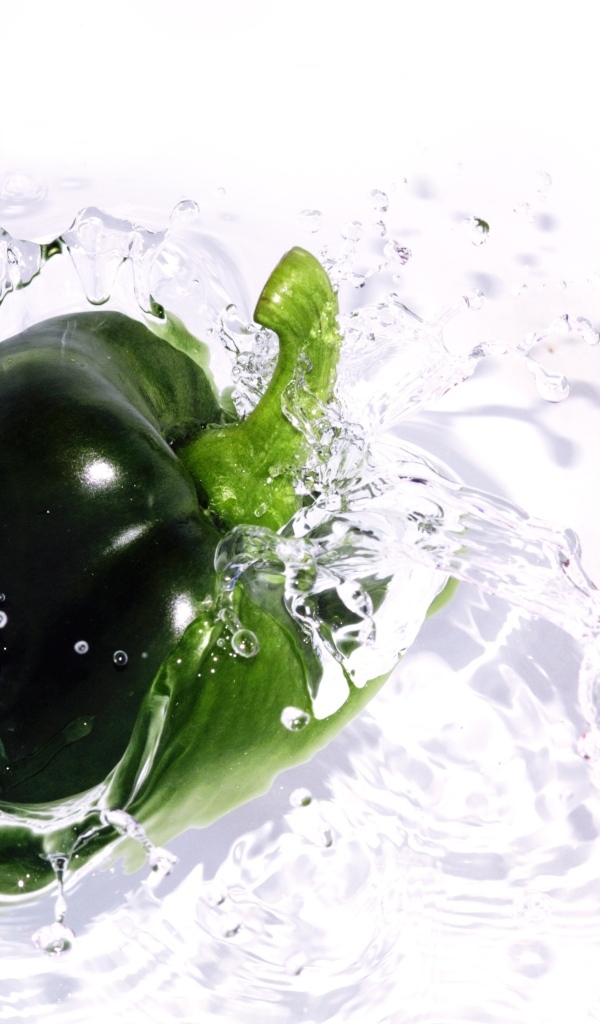 Зеленый перец в воде на белом фоне