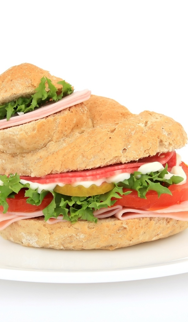 Гамбургер с колбасой, томатами и листьями салата на белом фоне