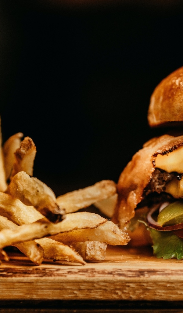 Сочный гамбургер на столе с картофелем фри