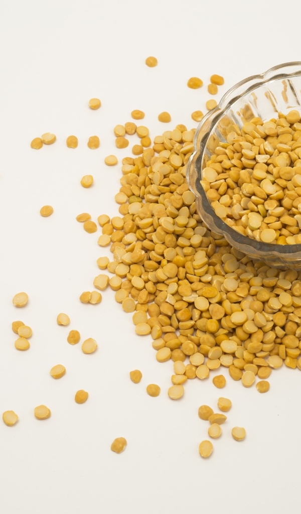 Чечевица рассыпана на белом фоне