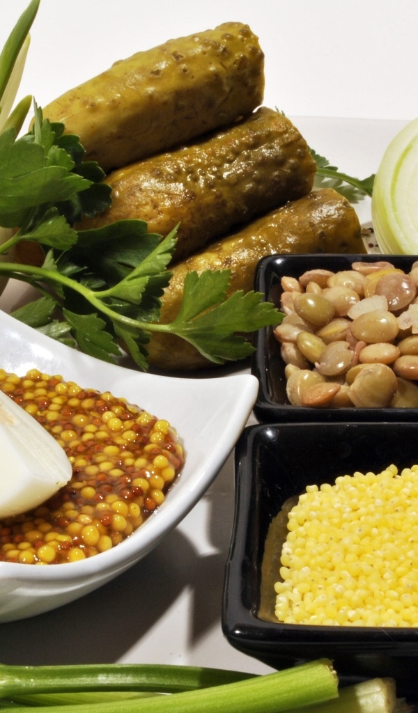 Пшено на столе с огурцами луком и горчицей