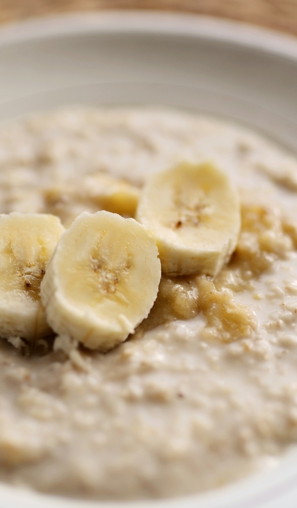Овсяная каша с кусочками банана в тарелке