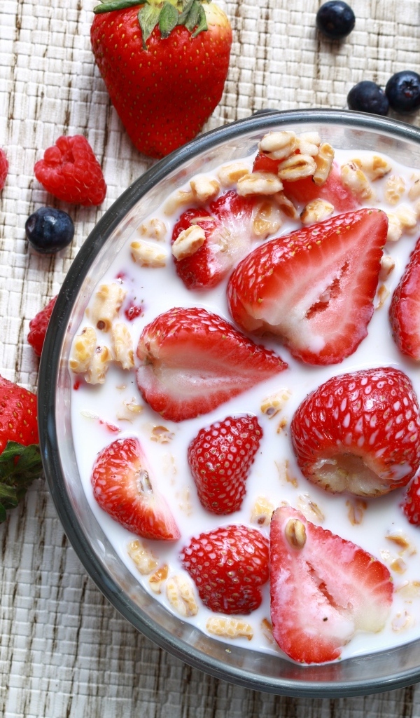 Овсянка с молоком в тарелке с ягодами малины