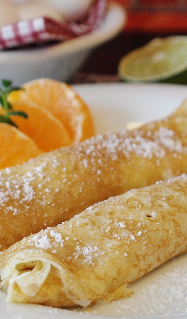 Блина на тарелке с дольками апельсина