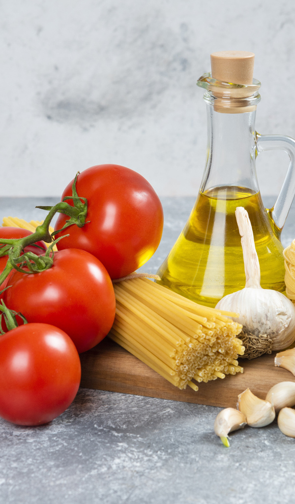 Паста, помидоры и масло на столе