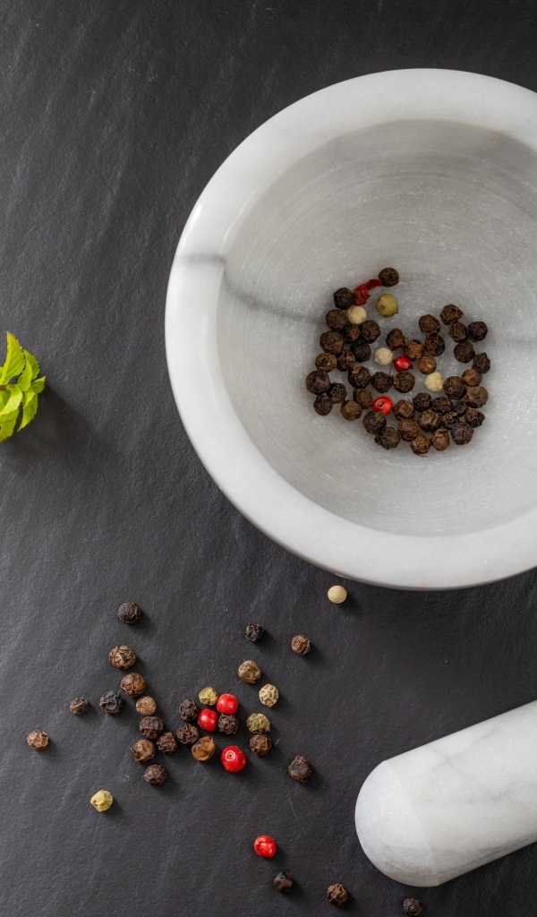 Перец горошком в ступе на сером столе