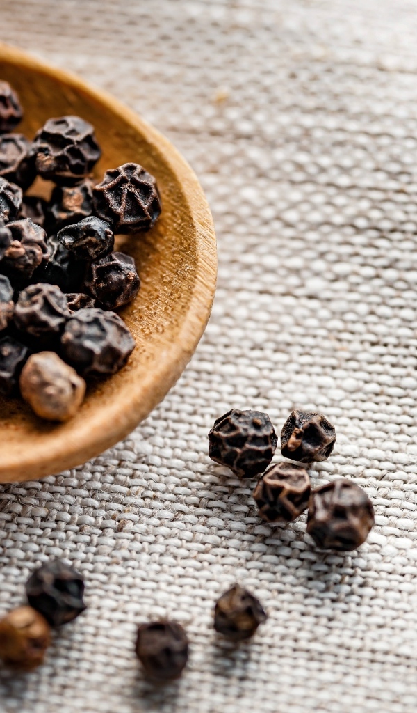 Перец горошком на деревянной ложке