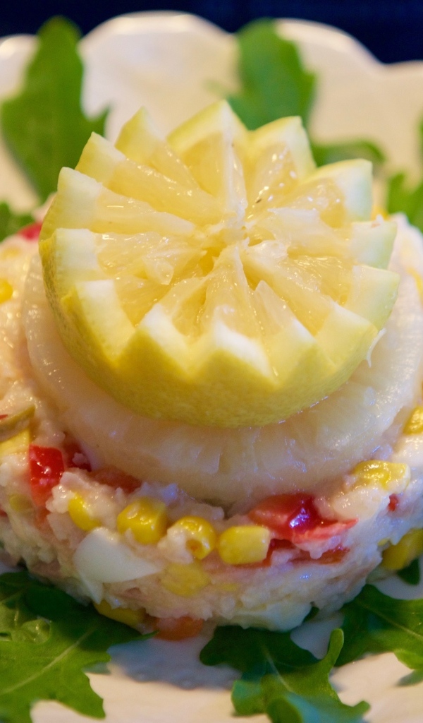 Салат на тарелке с лимоном и рукколой