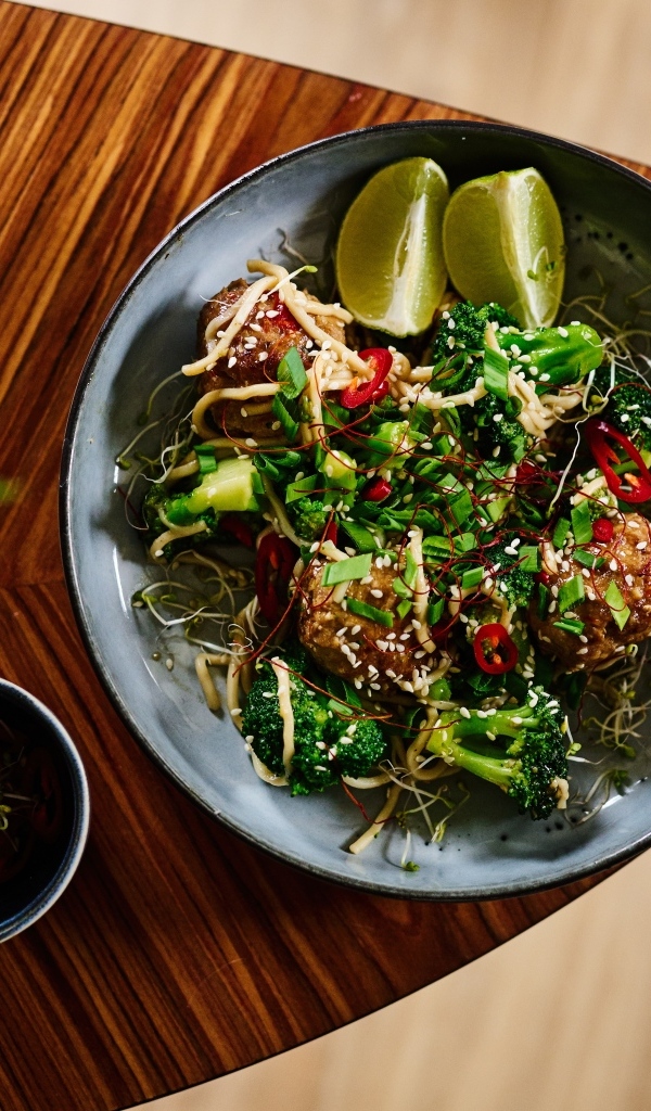 Салат на тарелке с кусочками лайма