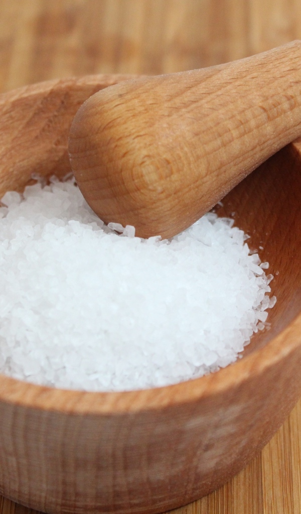 Соль в деревянной ступке на столе 