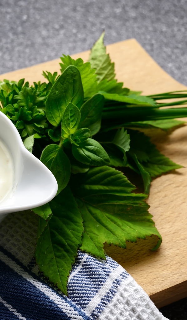 Соус с зеленью на деревянной доске 