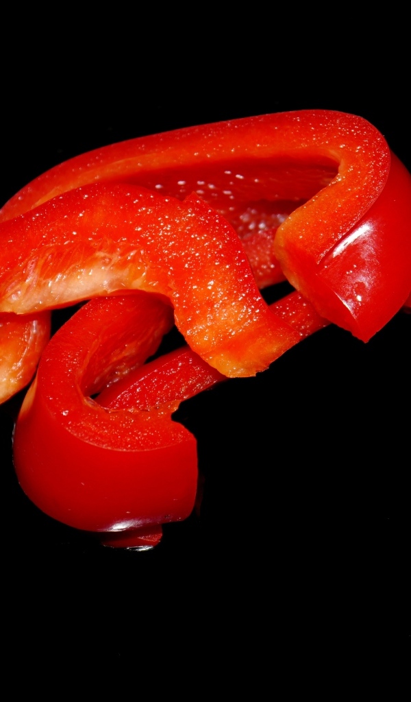 Нарезанный сладкий красный перец на черном фоне