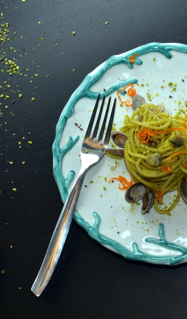 Спагетти с морепродуктами на столе с апельсинами