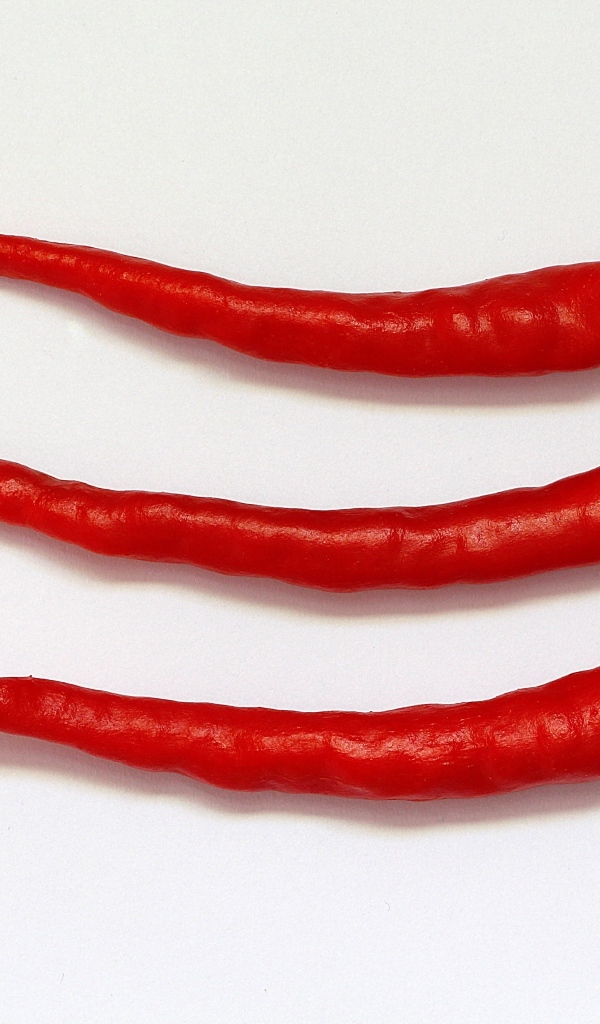 Три перца чили на сером фоне