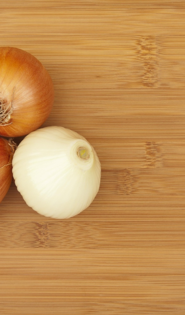 Три луковицы на деревянном столе