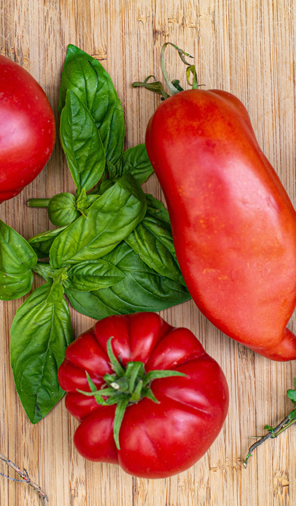 Помидоры  на разделочной доске с базиликом