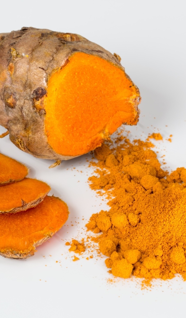 Корень куркумы с порошком на сером фоне
