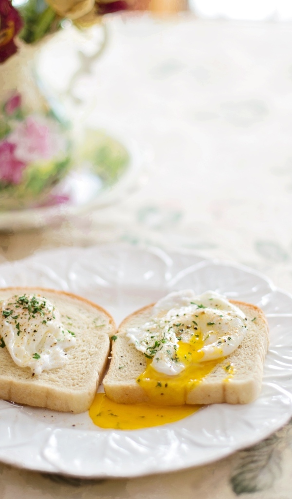 Два куска хлеба с яйцом на тарелке на завтрак