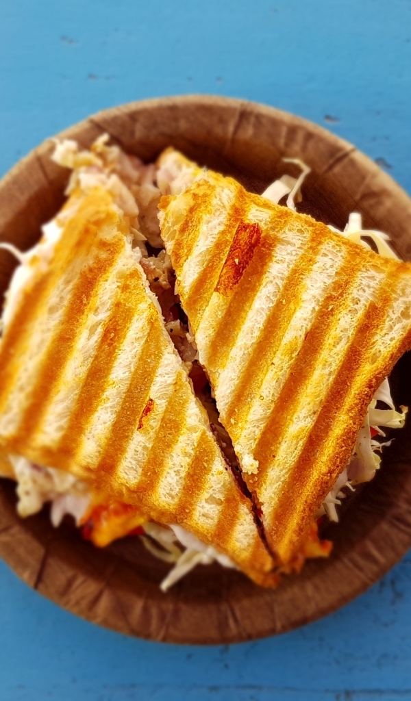 Два сэндвича на тарелке на голубом столе