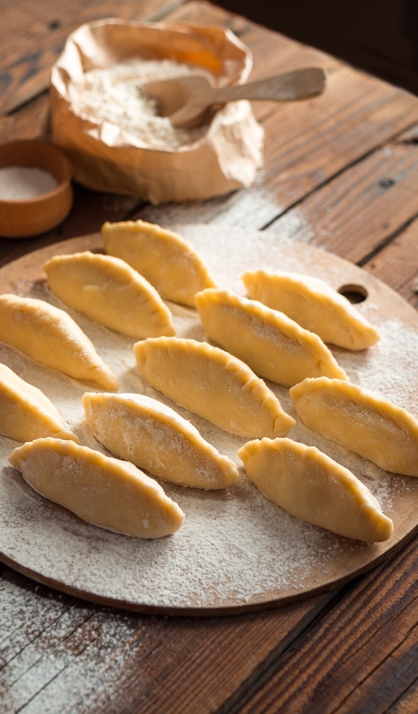 Вареники на столе с мукой и яйцами