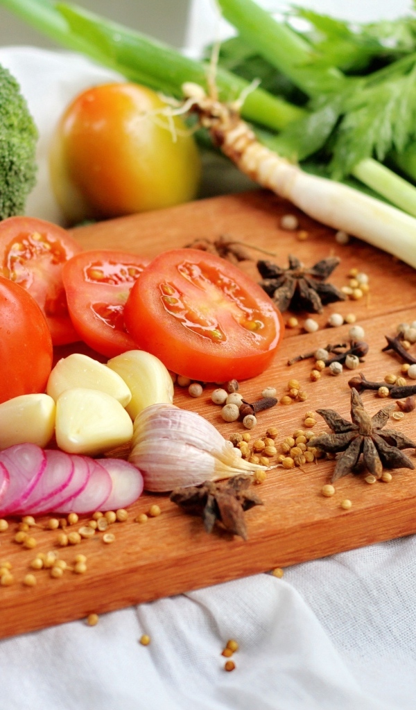 Овощи с зеленью на разделочной доске 