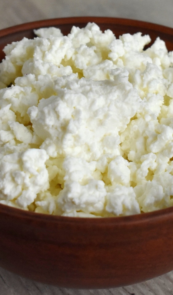 Деревянная миска с творогом на столе