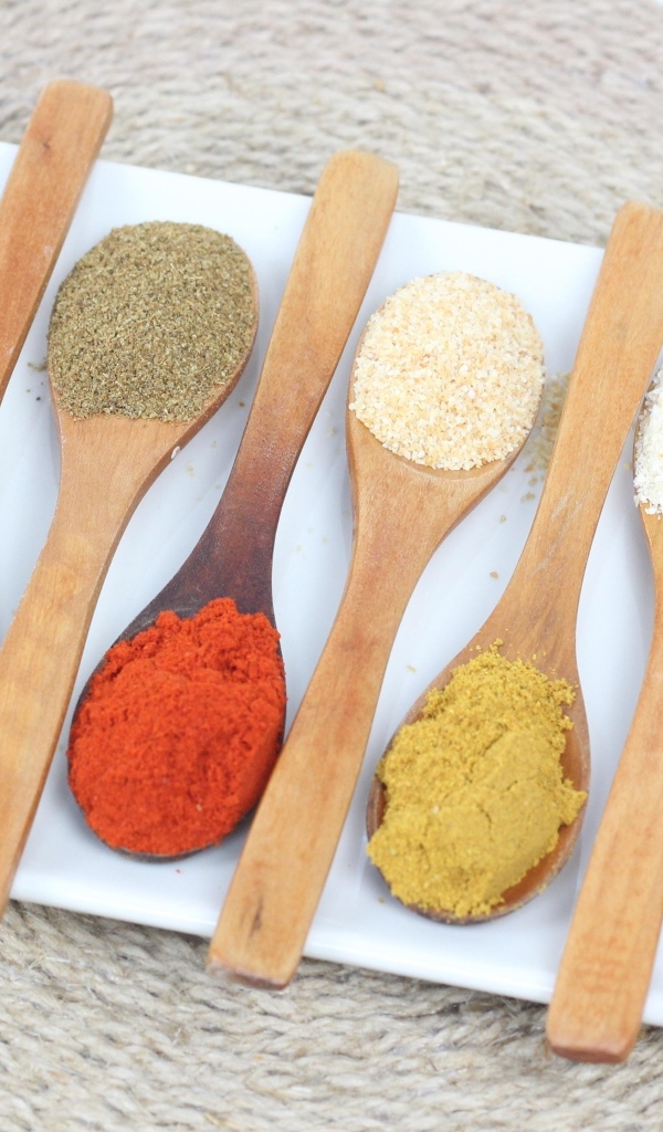 Деревянные ложки с пряными специями на салфетке 