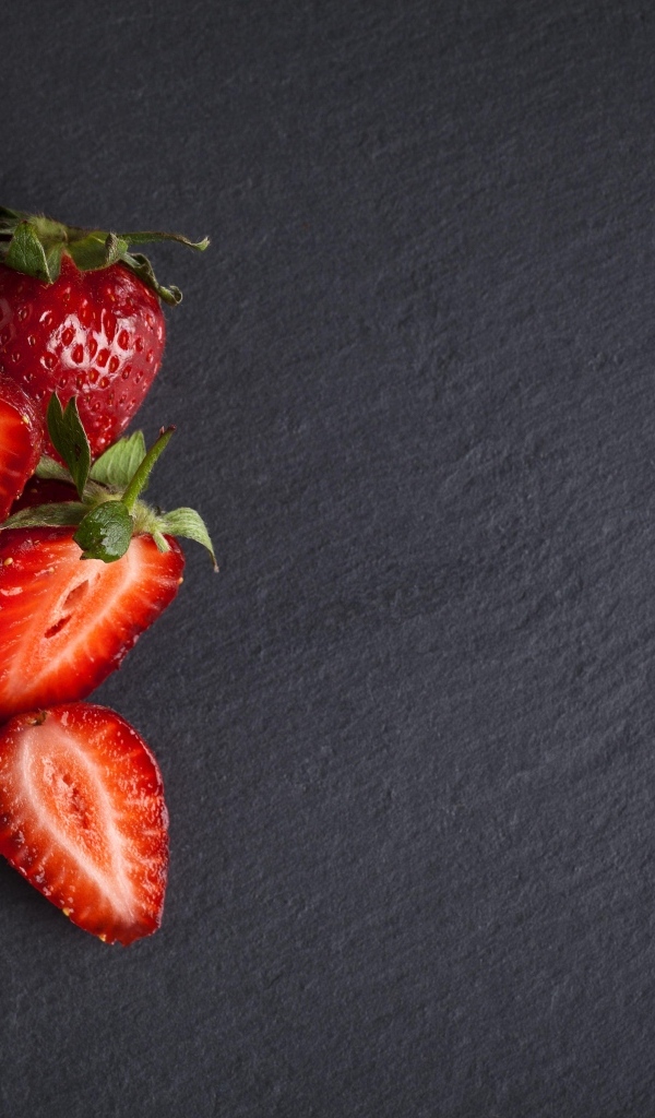 Горсть спелой клубники на сером столе