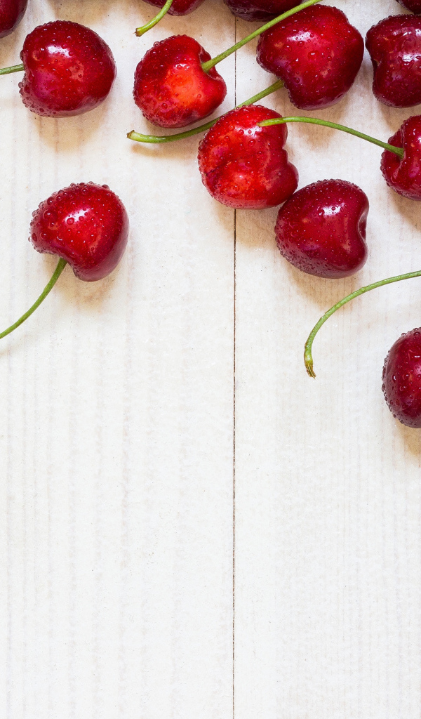 Аппетитные свежие красные ягоды черешни на белом столе