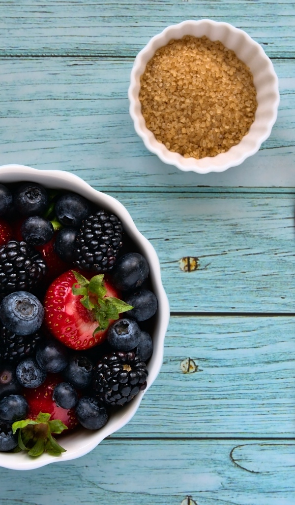 Аппетитные спелые ягоды в тарелке на столе