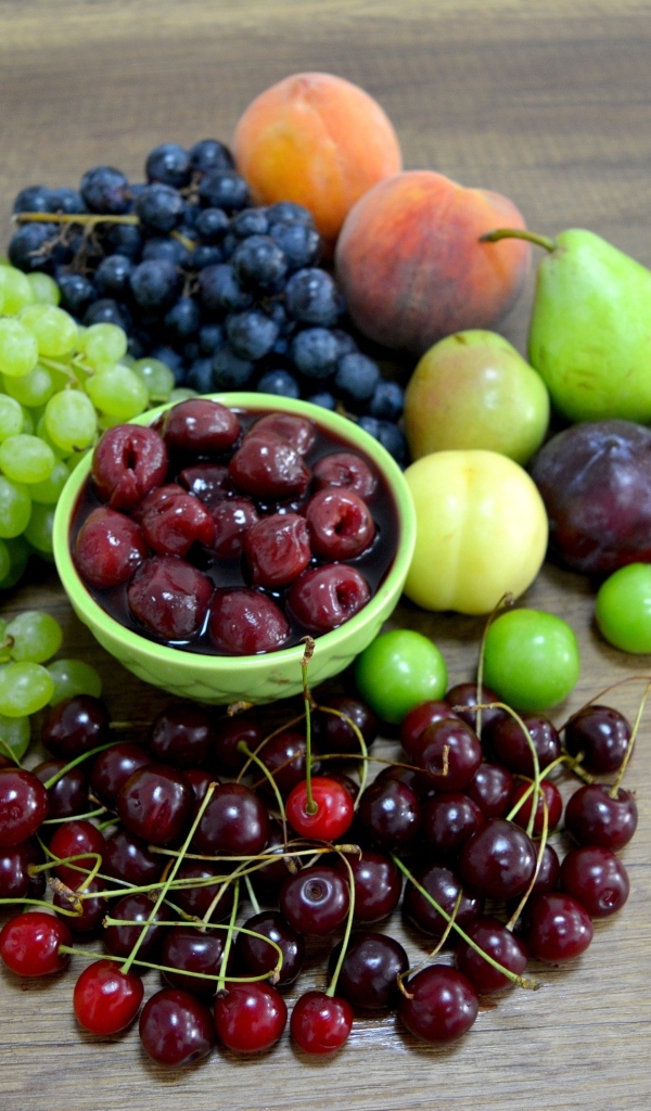 Аппетитные сладкие фрукты и ягоды на деревянном столе