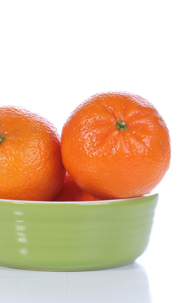 Красивые мандарины в миске на белом фоне