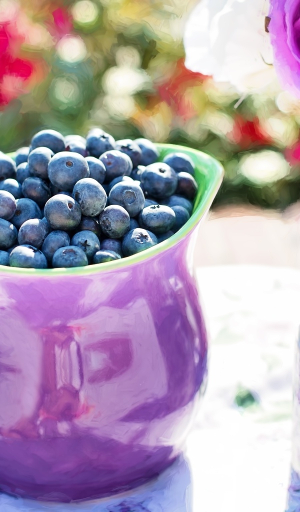 Ягоды черники в кувшине на столе