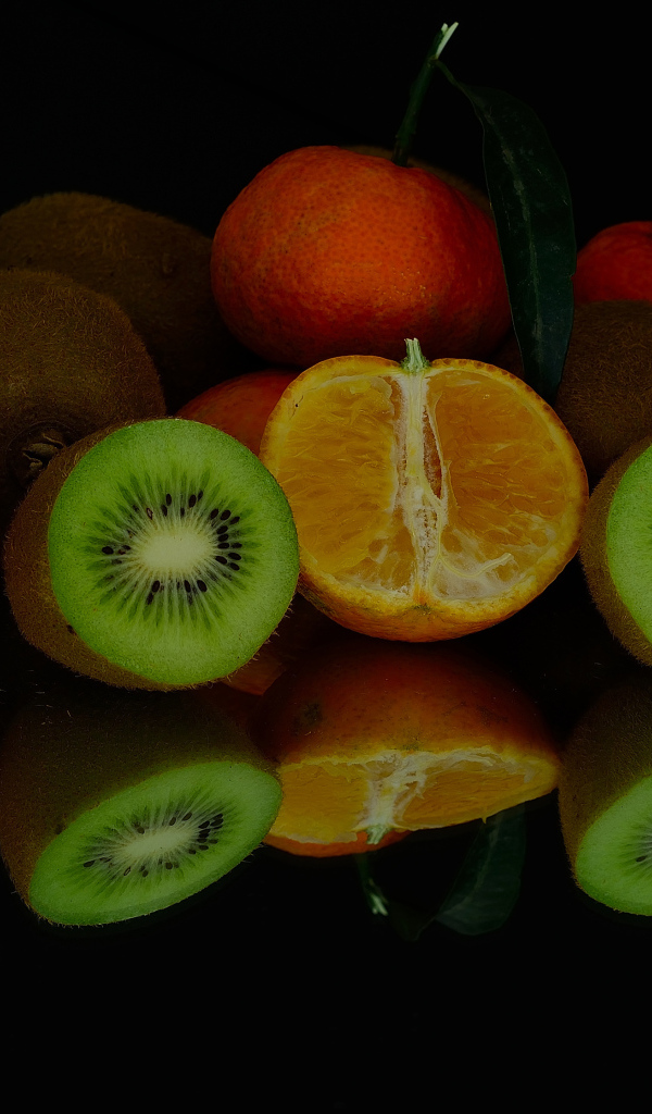 Цитрусовые фрукты на черной зеркальной поверхности