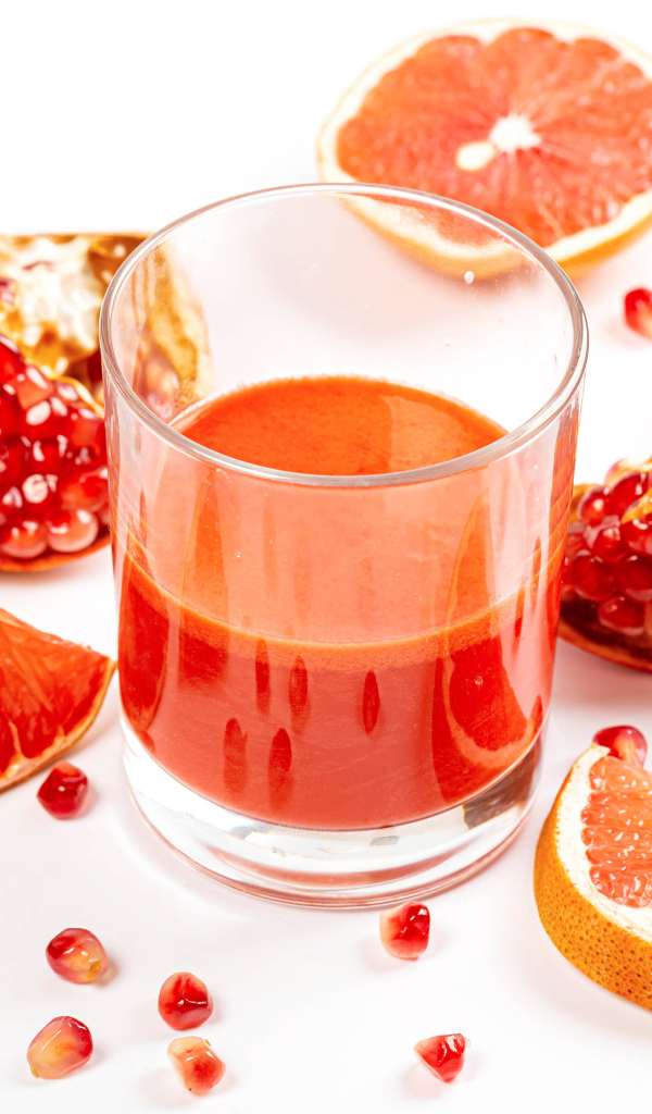 Грейпфрут и гранат на столе с соком