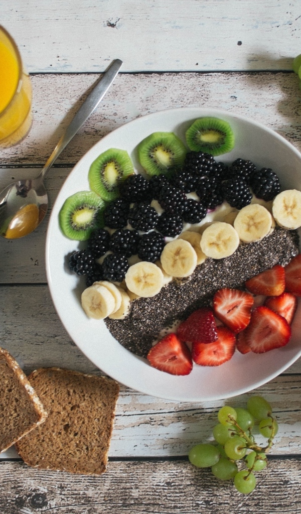 Полезный завтрак с ягодами и фруктами на столе с соком